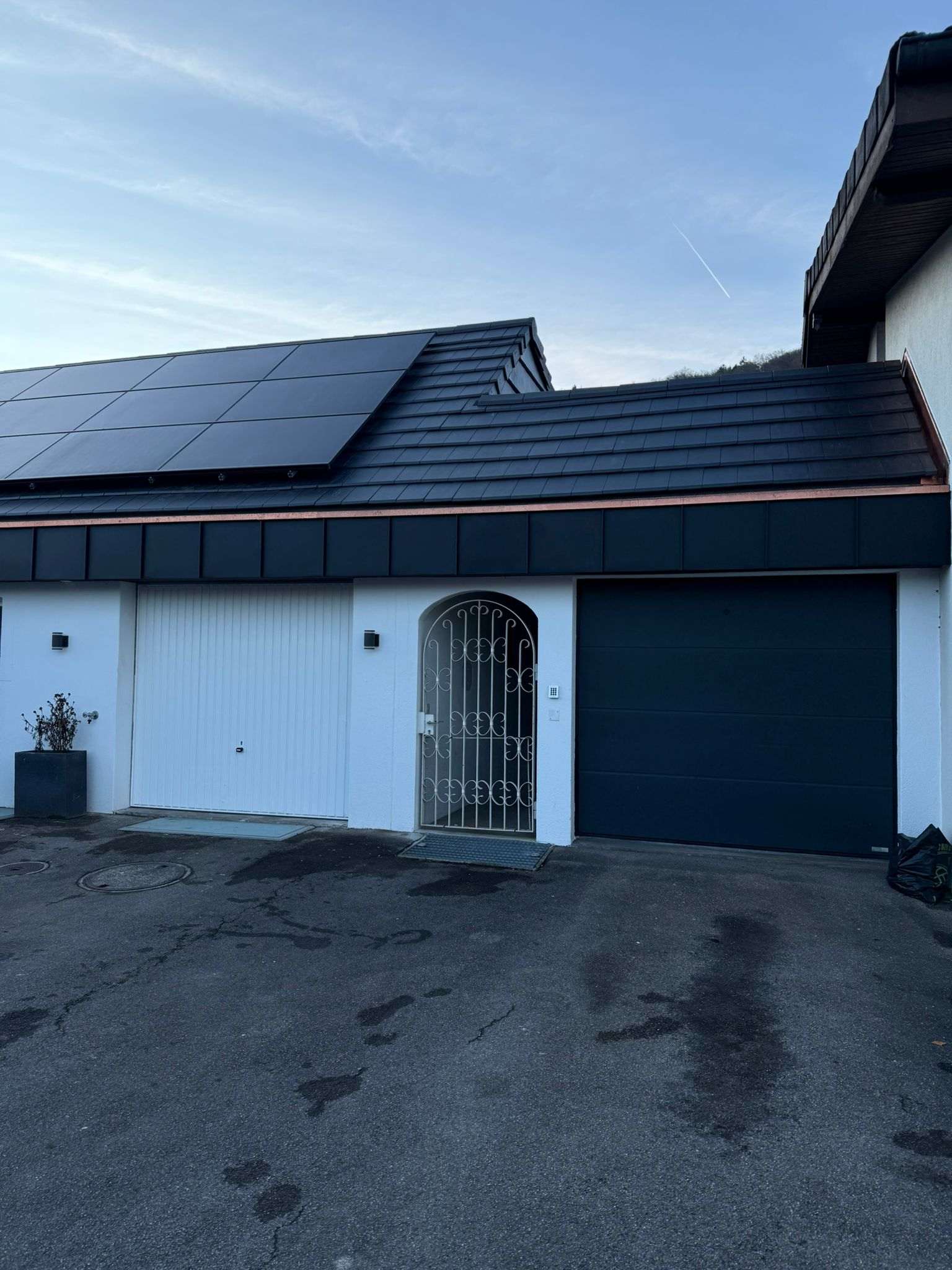 Saniertes Einfamilienhaus mit anthrazitfarbener Ziegeleindeckung, Kupferabschlüssen und Indach-Photovoltaikanlage